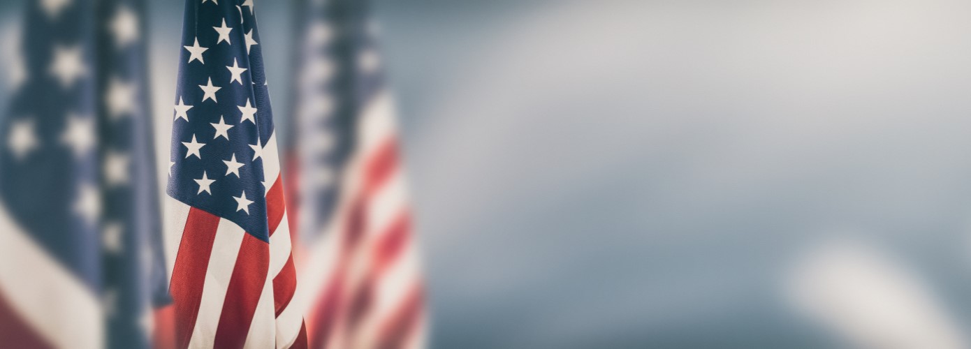 Three American flags on upright flag poles