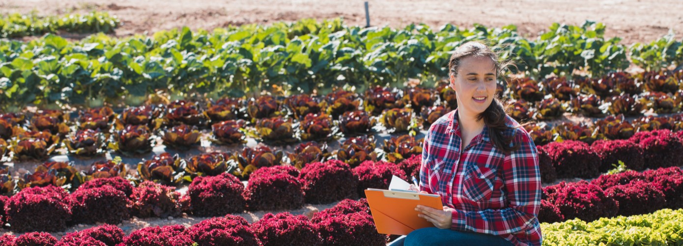 Woman with clipboard in farm field