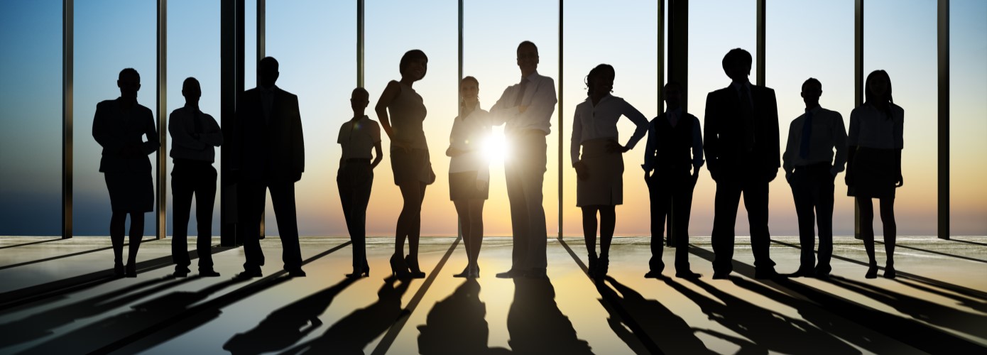 Group of people in shadow with bright light behind